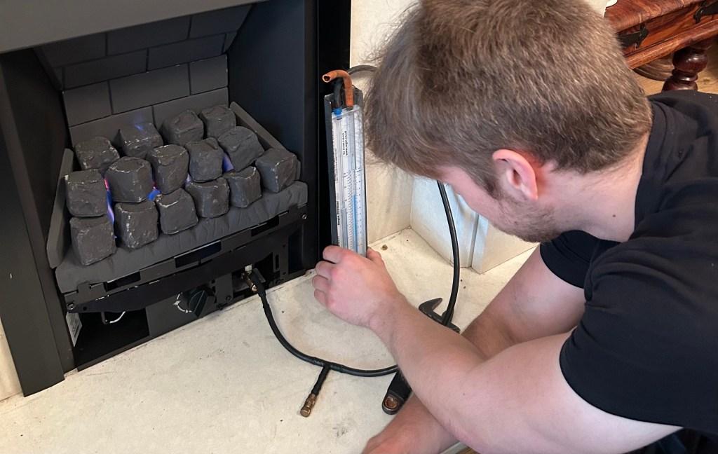 Gas engineer carrying out a gas fire service